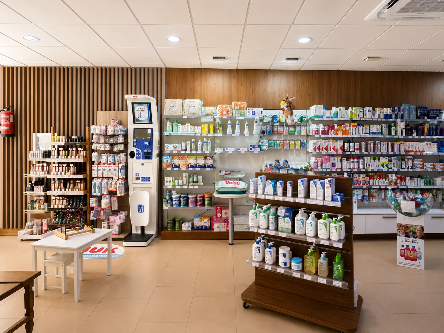 Zona infantil con báscula de bebé y expositor de dermofarmacia en Farmacia Vázquez Bormujos