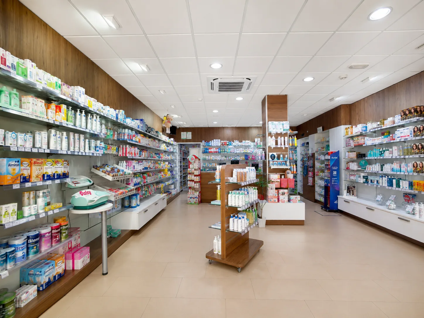 Vista interior de Farmacia Vázquez en Bormujos — pasillo central con alimentación infantil y dermofarmacia